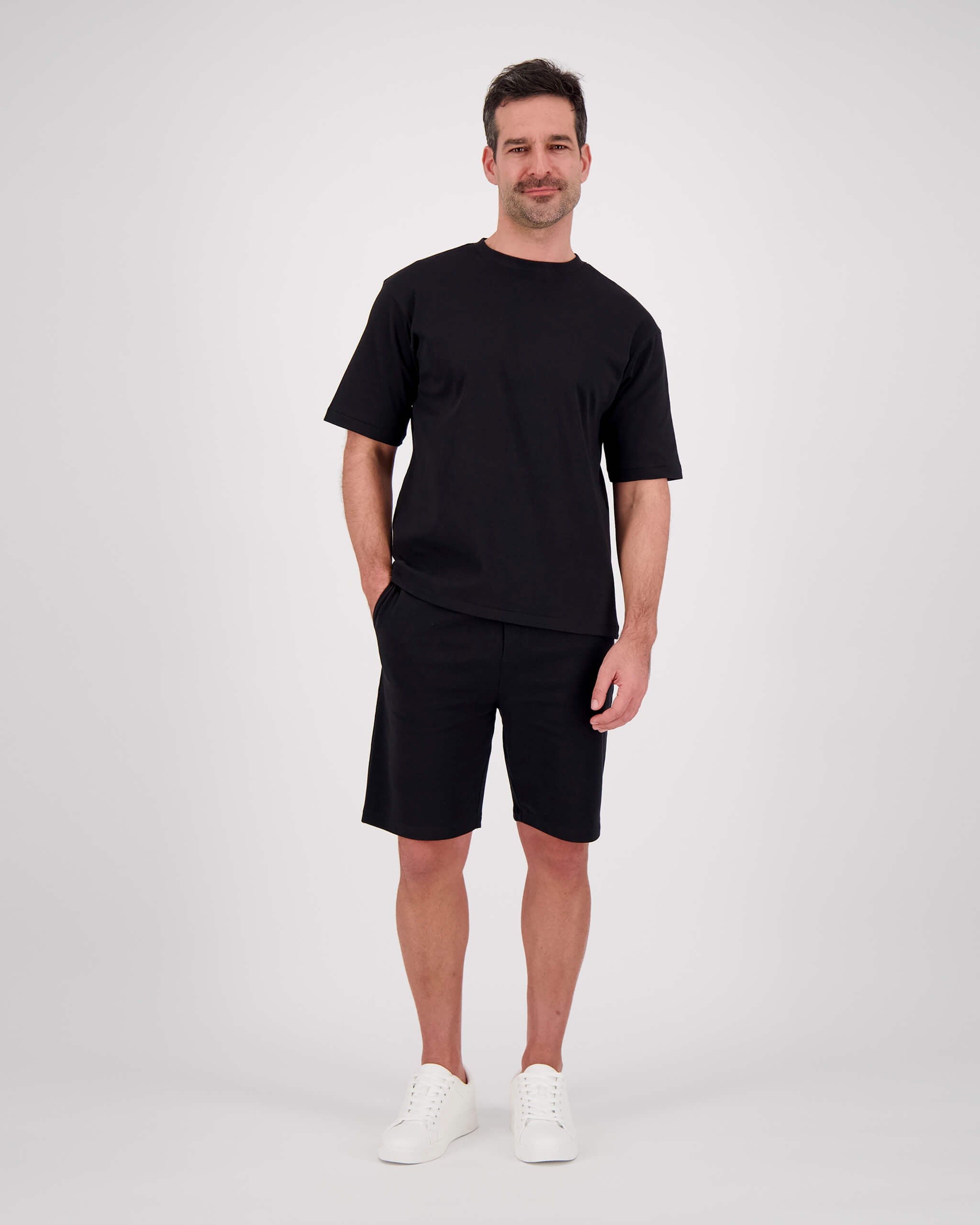 Vorderseite Model posiert mit T-Shirt Paul für den Mann in der Farbe Schwarz