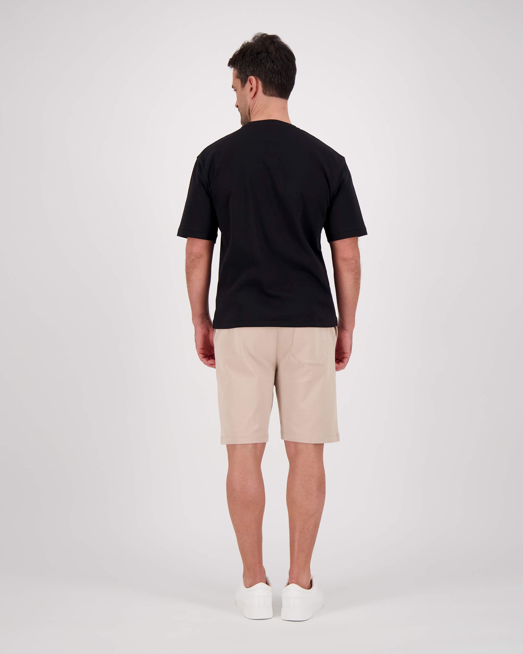 Rückseite Model posiert mit T-Shirt Paul für den Mann in der Farbe Schwarz